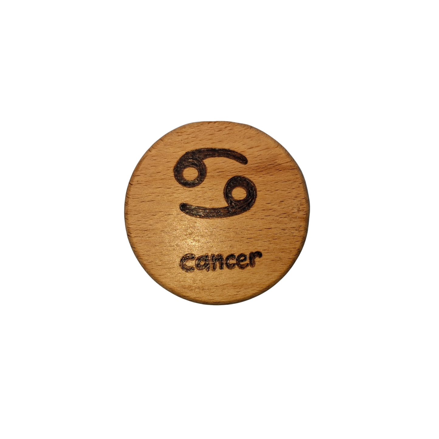 Close-up of a light-colored beechwood circle, 5cm in diameter and 0.4cm thick, featuring the words "Cancer" and an illustration of the star sign symbol, hand-burned into its surface using pyrography. The wood has a smooth, waxed finish and the text is clearly legible.
