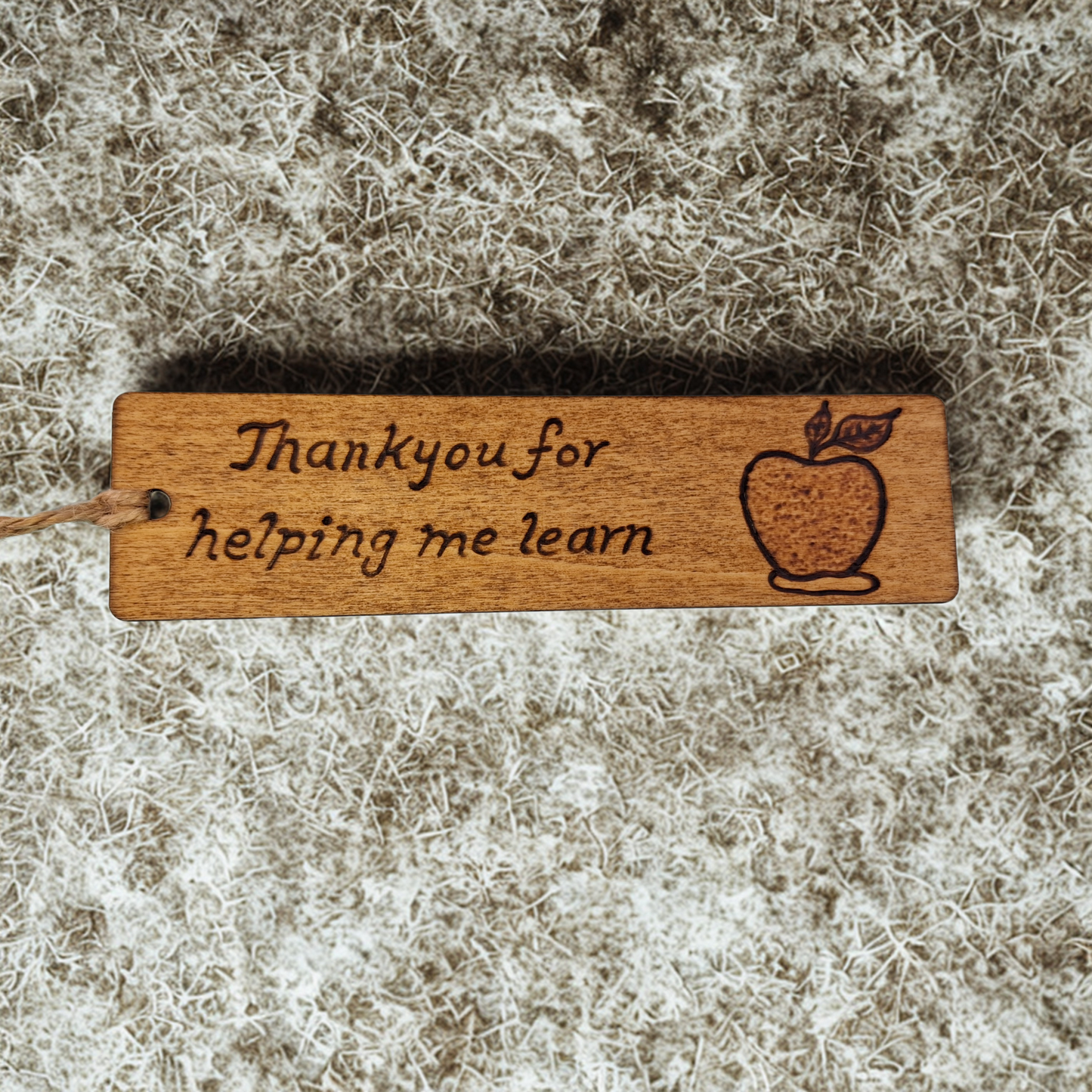Dark wood bookmark with "Thankyou for helping me learn" pyrography and an apple illustration.