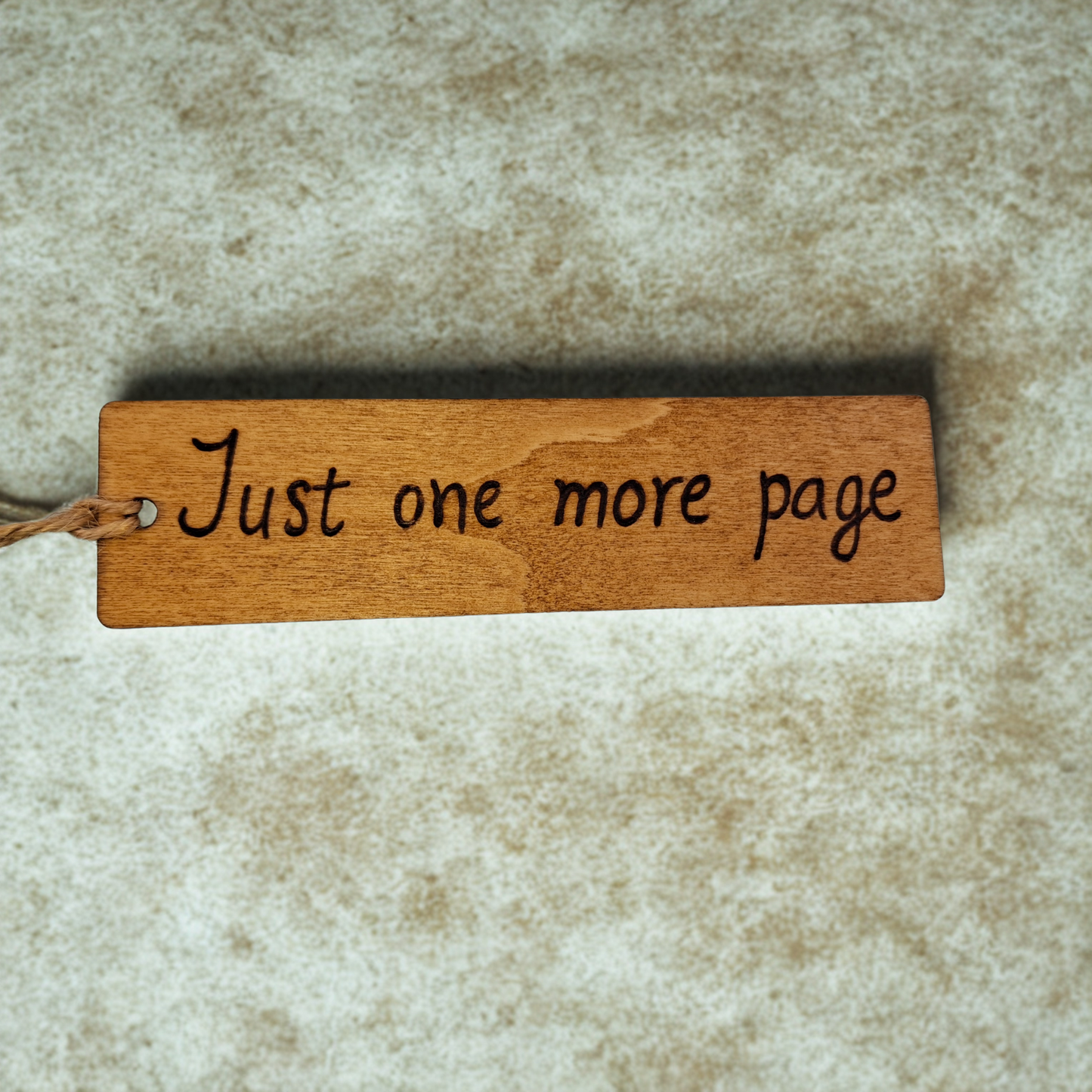 Dark wood bookmark with "Just one more page" pyrography.