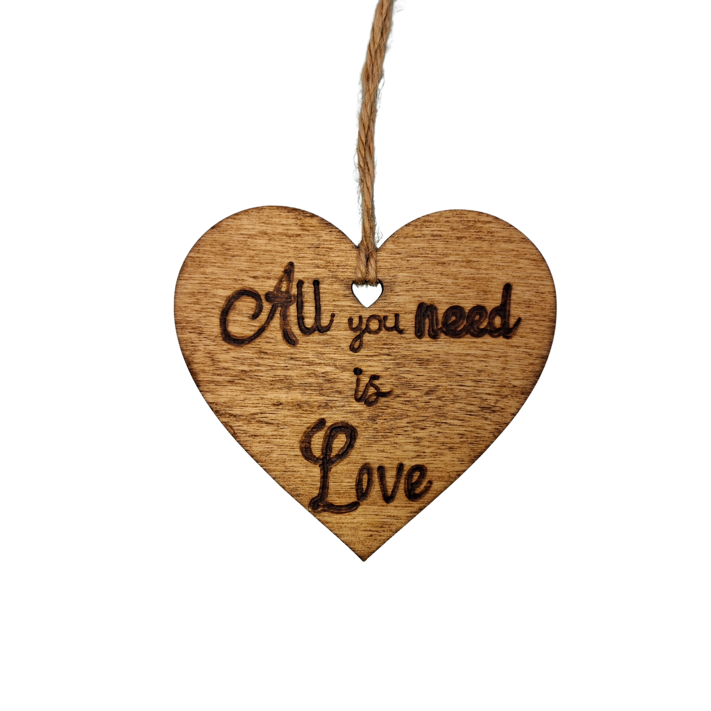Heart-shaped wooden ornament, hand-drawn with pyrography, featuring the engraved phrase "All you need is Love" in a decorative script.