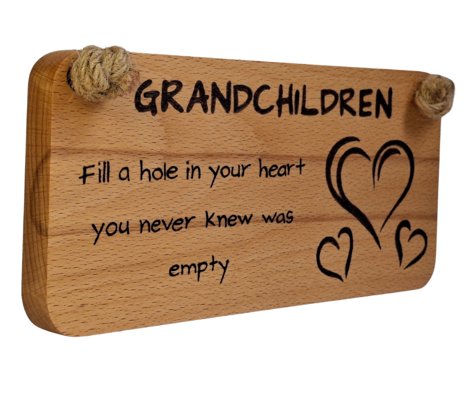 Wooden plaque hand-burnt with "Grandchildren fill a hole in your heart you never knew was empty" pyrography and three heart illustrations, hung by a thick jute rope.