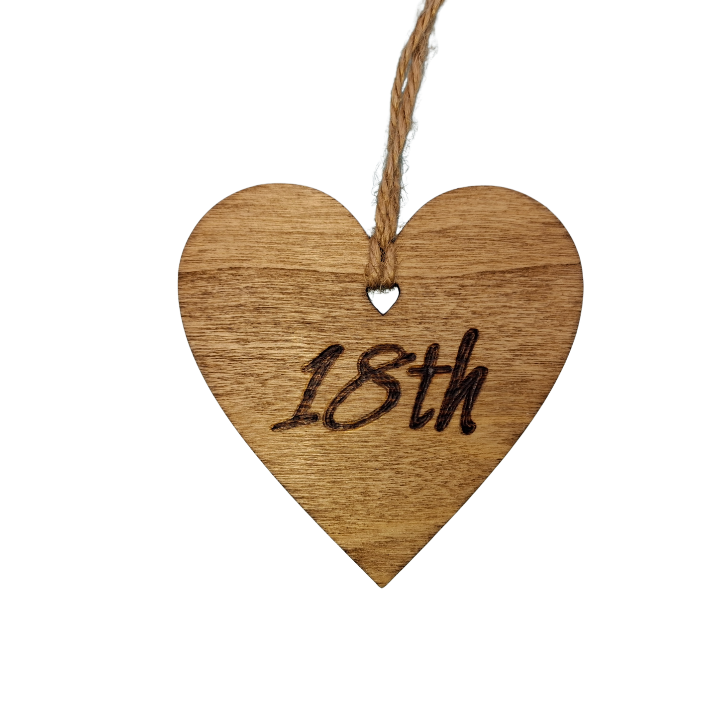A small, possibly 8cm by 8cm, light-colored wooden heart, decorated with "18th" hand-burned into its surface using pyrography. A short length of natural jute rope is tied through the top for hanging.