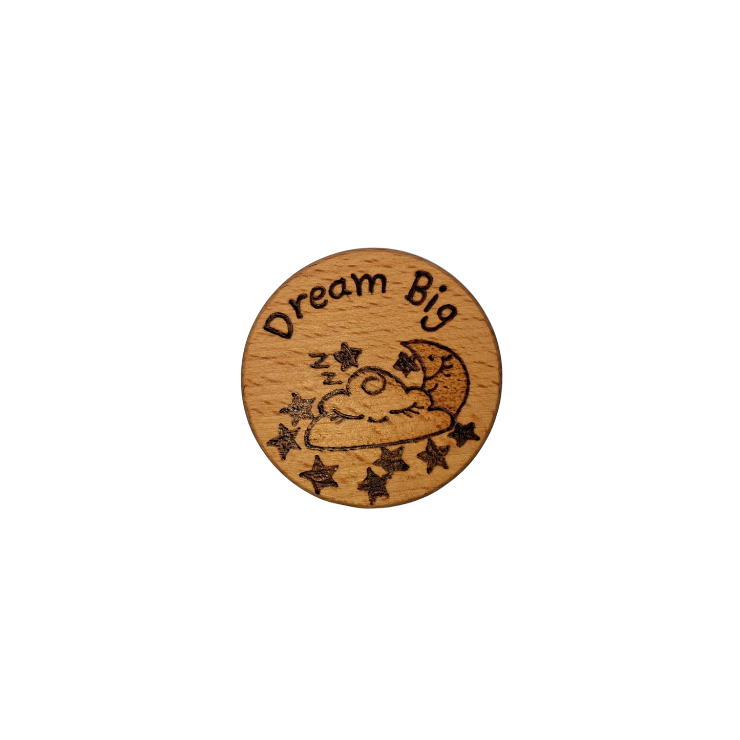 Close-up of a light-colored beechwood circle, 5cm in diameter and 0.4cm thick, featuring the words "Dream Big" and an illustration of a sleeping cloud, moon and stars hand-burned into its surface using pyrography. The wood has a smooth, waxed finish and the text is clearly legible.