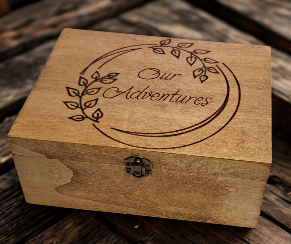 Custom wood-burnt memory box featuring "Our Adventures" in a round frame adorned with intricate leaf pyrography