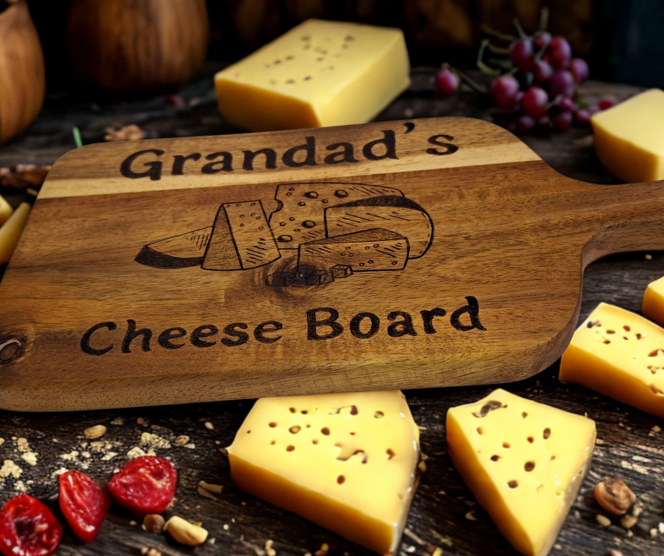 A multicolored, hand-decorated pyrography chopping board with the words "Grandad's Cheese Board" and illustrations of cheese chunks.