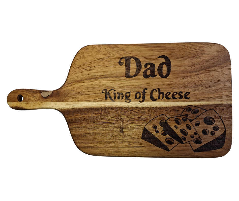 A multicolored, hand-decorated pyrography chopping board with the words "Dad King of Cheese" and illustrations of cheese chunks.