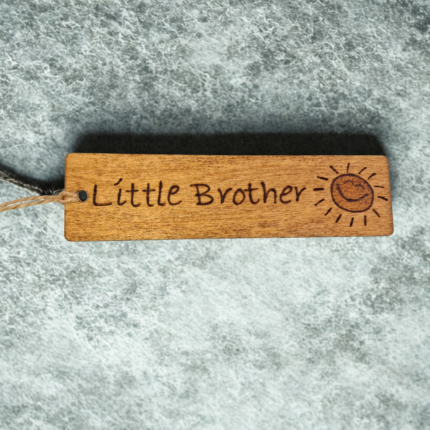 Dark wood bookmark with "Little Brother" pyrography smiling sunshine illustration.