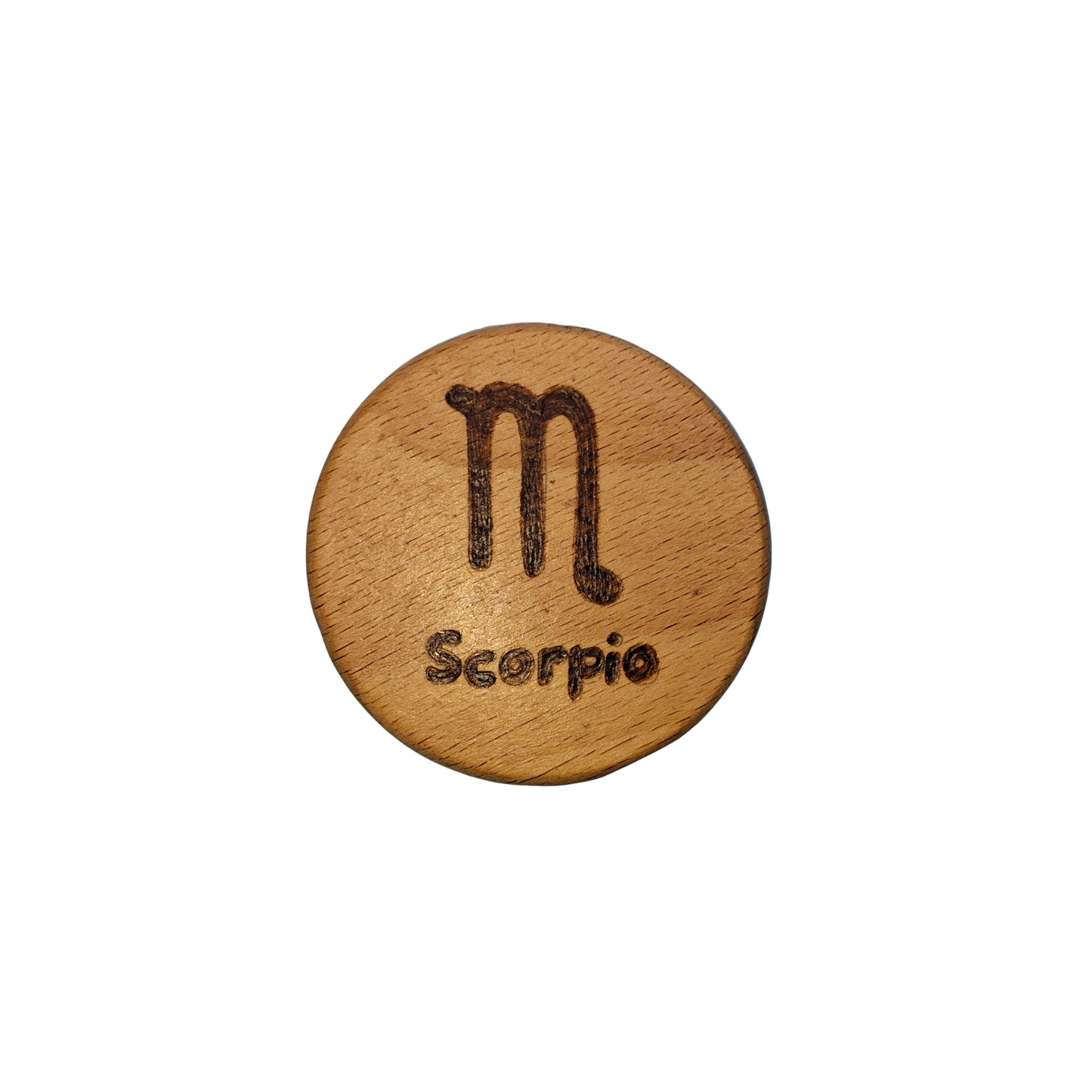 Close-up of a light-colored beechwood circle, 5cm in diameter and 0.4cm thick, featuring the words "Scorpio" and an illustration of the star sign symbol, hand-burned into its surface using pyrography. The wood has a smooth, waxed finish and the text is clearly legible.