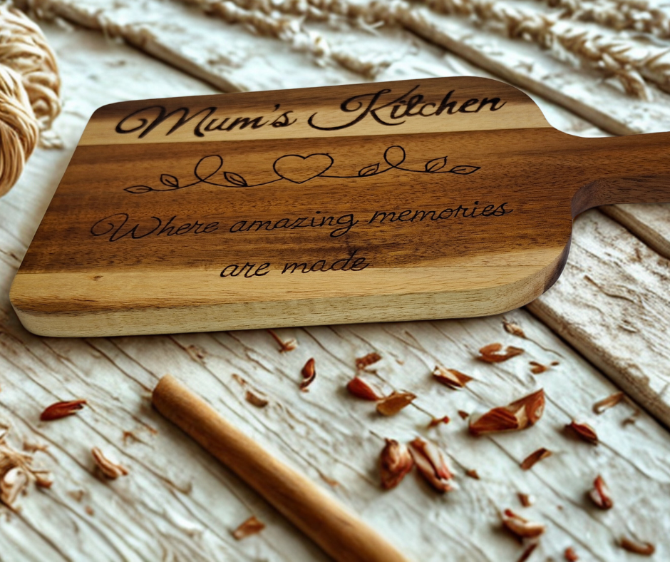 A multicolored, hand-decorated pyrography chopping board with the words "Mum's Kitchen where amazing memories are made" and a heart divider.