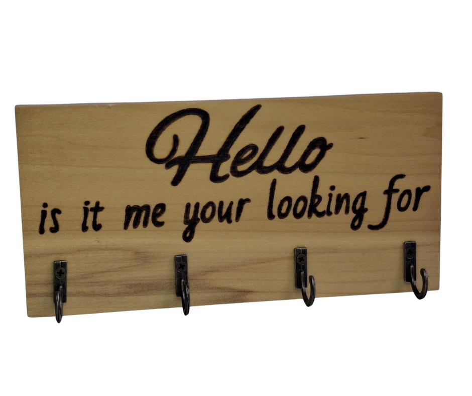 A four-hook hanger crafted from two-tone Tulipwood, featuring hand-burnt lettering that reads "Hello, Is It Me You're Looking For?" The wood has visible grain, showcasing its natural variations.
