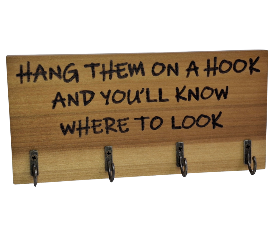A four-key hook hanger crafted from two-tone Tulipwood, featuring hand-burnt lettering that reads "Hang them on a hook so you know where to look." The wood has visible grain, showcasing its natural variations.