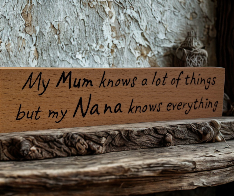 A hand-burnt, freestanding wooden plaque with the words "My Mum knows most things but my Nana knows everything" in a casual, handwritten style. The wood has visible grain and a rustic, natural finish.