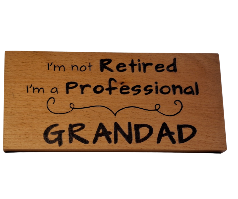Wooden plaque hand-decorated with "I'm not retired I'm a professional Grandad" pyrography.