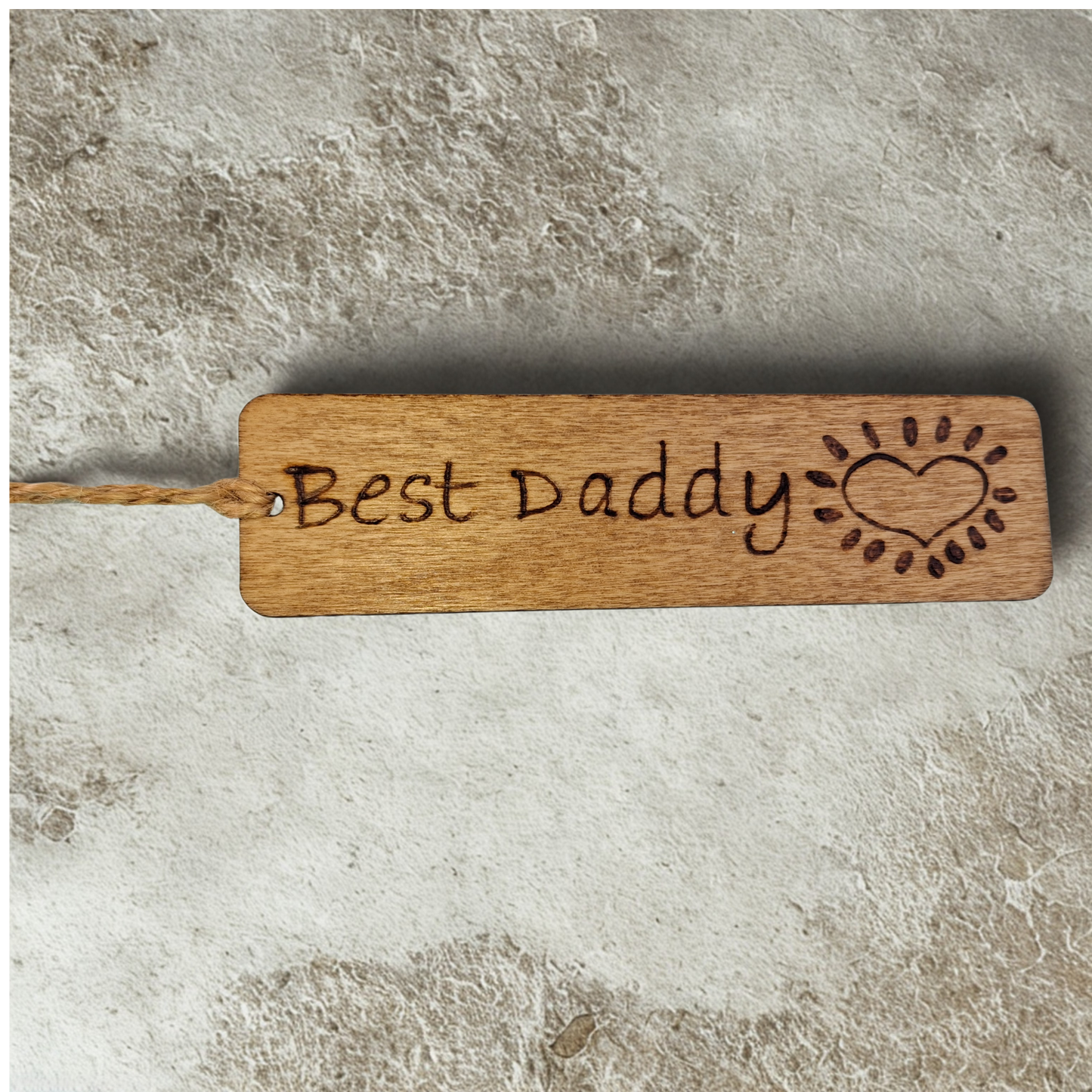 Dark wood bookmark with "Best Daddy" pyrography and a heart illustration.