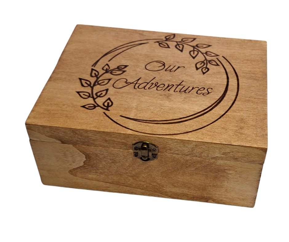 Custom wood-burnt memory box featuring "Our Adventures" in a round frame adorned with intricate leaf pyrography