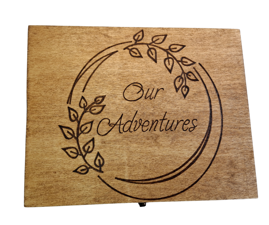Custom wood-burnt memory box featuring "Our Adventures" in a round frame adorned with intricate leaf pyrography