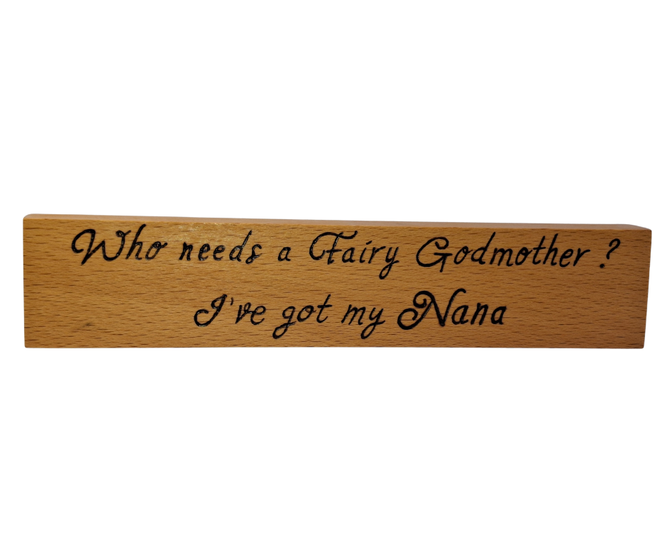 A hand-burnt, freestanding wooden plaque with the words "Who needs a fairy godmother I've got my Nana" in a casual, handwritten style. The wood has visible grain and a rustic, natural finish.