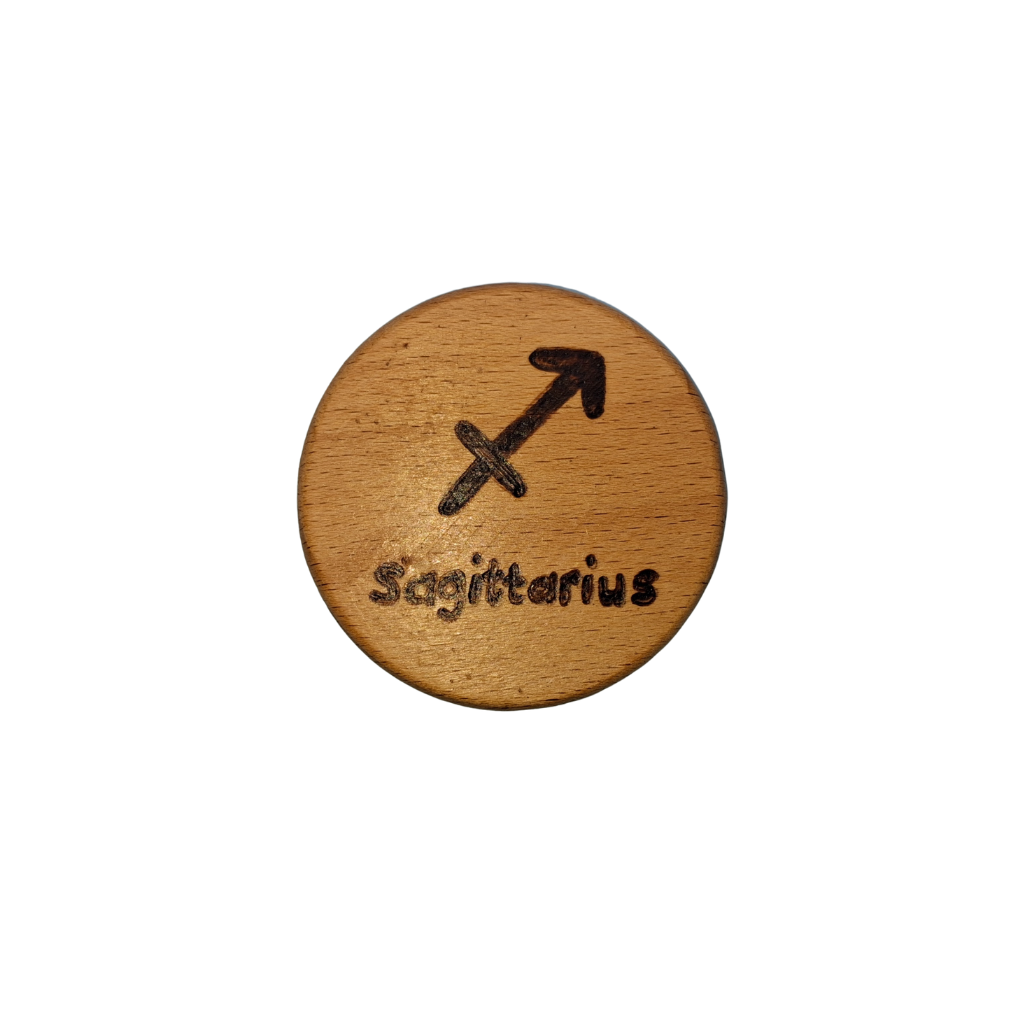 Close-up of a light-colored beechwood circle, 5cm in diameter and 0.4cm thick, featuring the words "Sagittarius" and an illustration of the star sign symbol, hand-burned into its surface using pyrography. The wood has a smooth, waxed finish and the text is clearly legible.