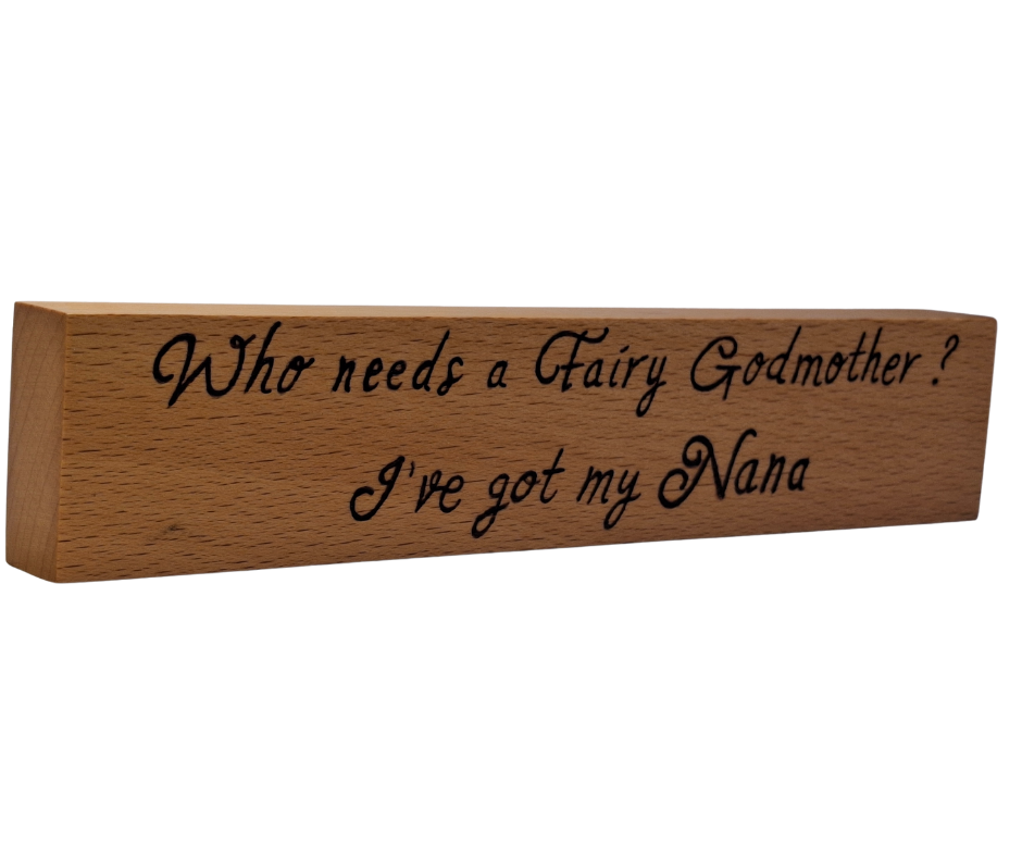 A hand-burnt, freestanding wooden plaque with the words "Who needs a fairy godmother I've got my Nana" in a casual, handwritten style. The wood has visible grain and a rustic, natural finish.