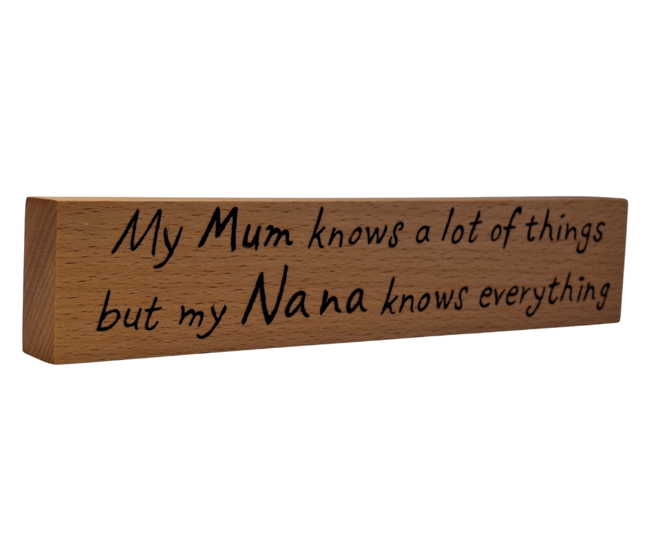 A hand-burnt, freestanding wooden plaque with the words "My Mum knows most things but my Nana knows everything" in a casual, handwritten style. The wood has visible grain and a rustic, natural finish.