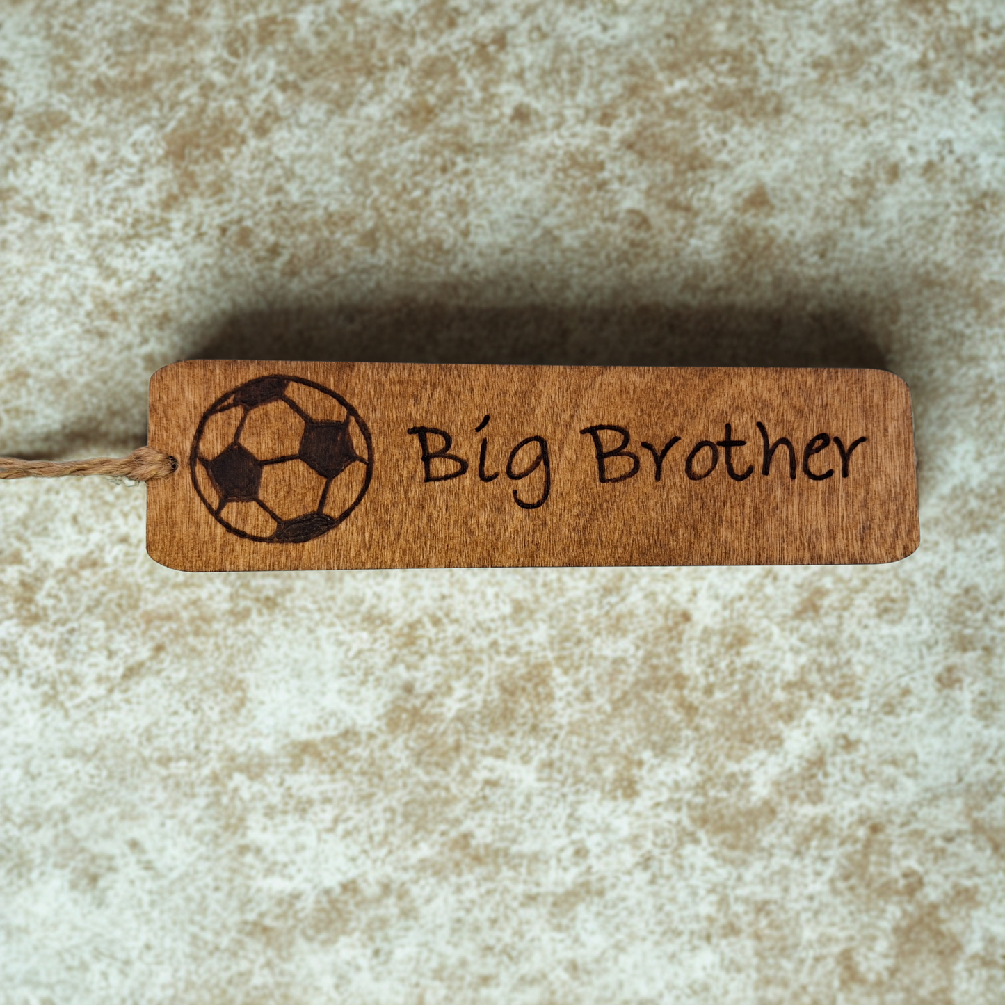Dark wood bookmark with "Big Brother" pyrography and a football illustration.