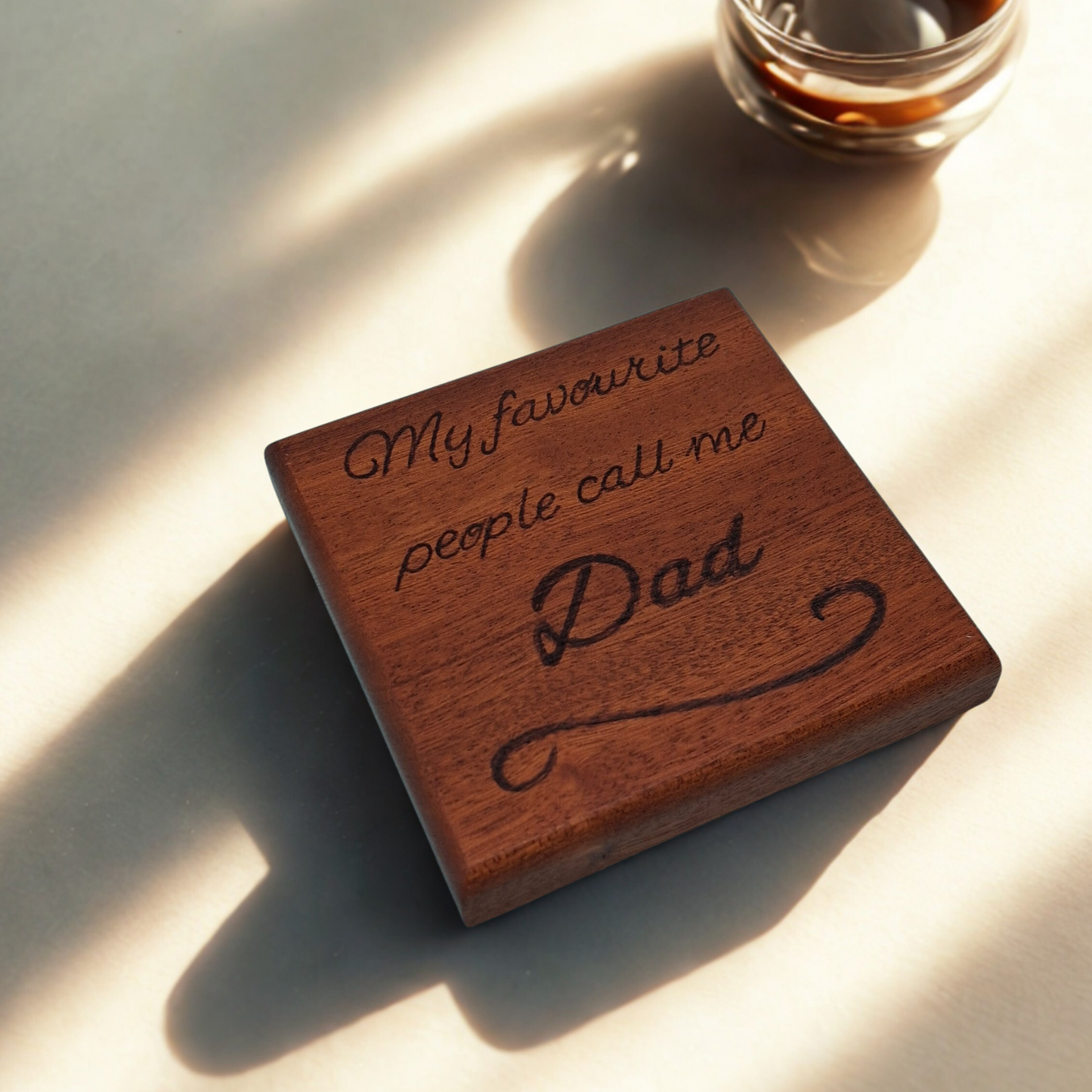 "Dark wooden coaster with pyrography text reading 'My favourite people call me Dad' with decorative flourish underneath"