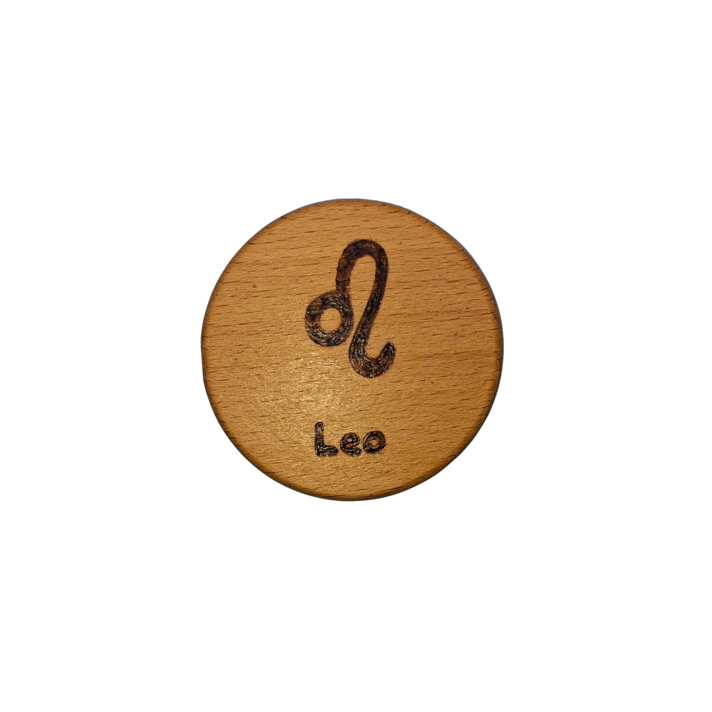 Close-up of a light-colored beechwood circle, 5cm in diameter and 0.4cm thick, featuring the words "Leo" and an illustration of the star sign symbol, hand-burned into its surface using pyrography. The wood has a smooth, waxed finish and the text is clearly legible.