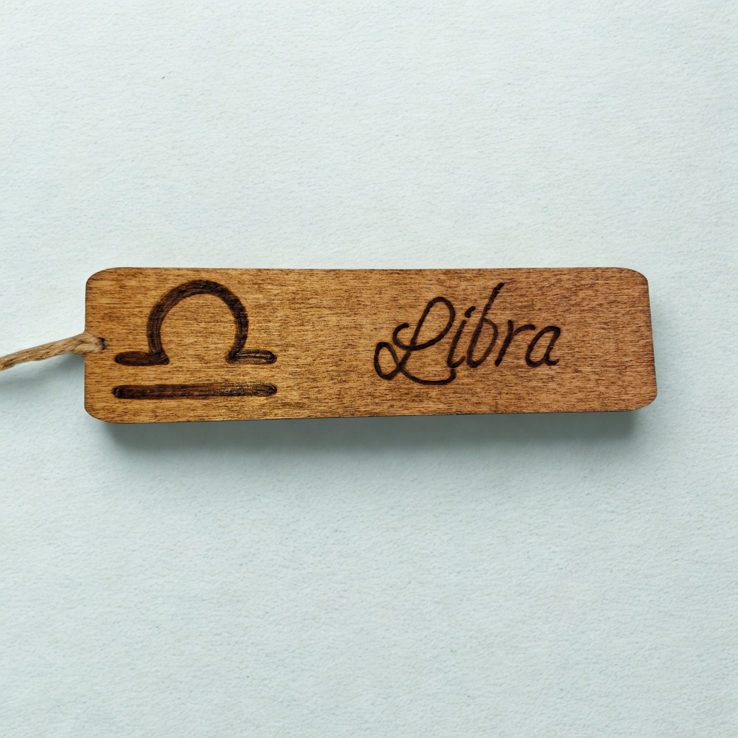 Dark wood bookmark with "Libra" pyrography and a star sign illustration.