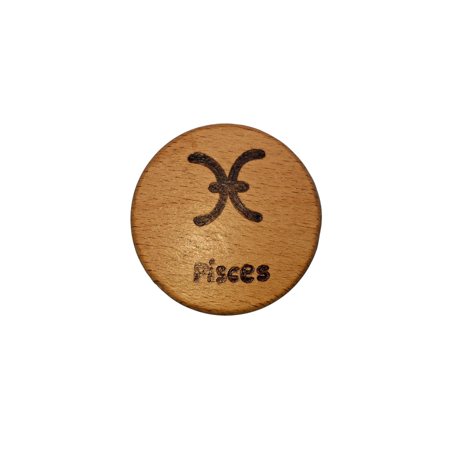 Close-up of a light-colored beechwood circle, 5cm in diameter and 0.4cm thick, featuring the words "Pisces" and an illustration of the star sign symbol, hand-burned into its surface using pyrography. The wood has a smooth, waxed finish and the text is clearly legible.