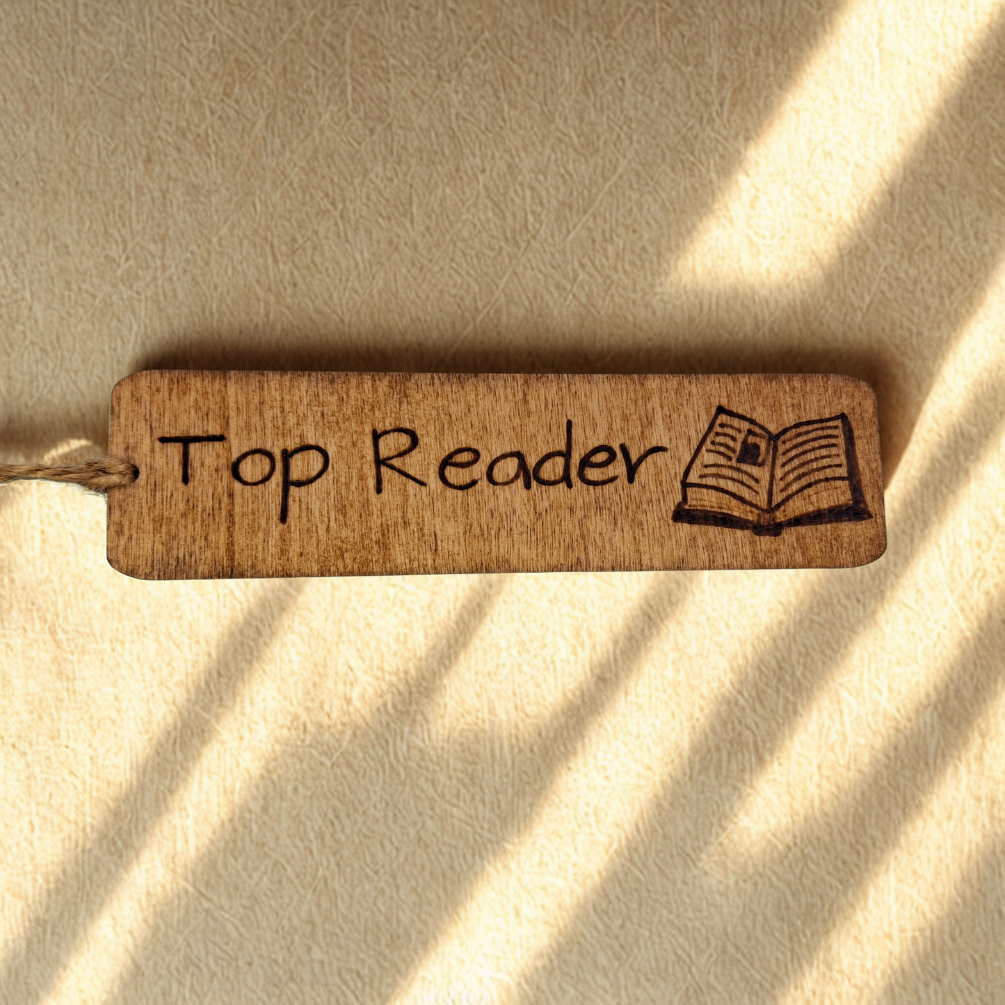 Dark wood bookmark with "Top Reader" pyrography and a open book illustration.