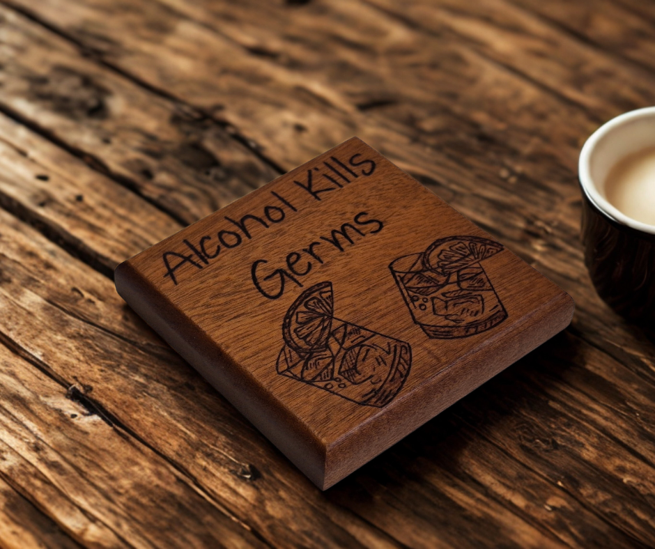 Sapele coaster with chamfered edges inscription "Alcohol Kills Germs" and a picture of 2 small glasses with lemon slices burnt in