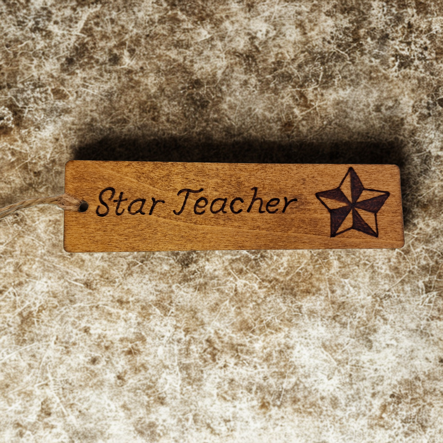 Dark wood bookmark with "Star Teacher" pyrography and a star illustration.