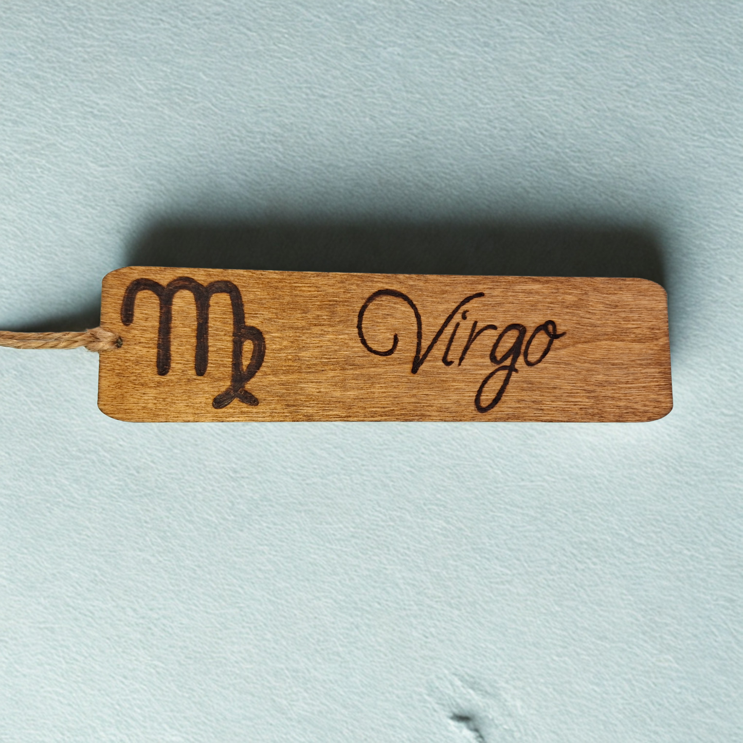 Dark wood bookmark with "Virgo" pyrography and a star sign illustration.