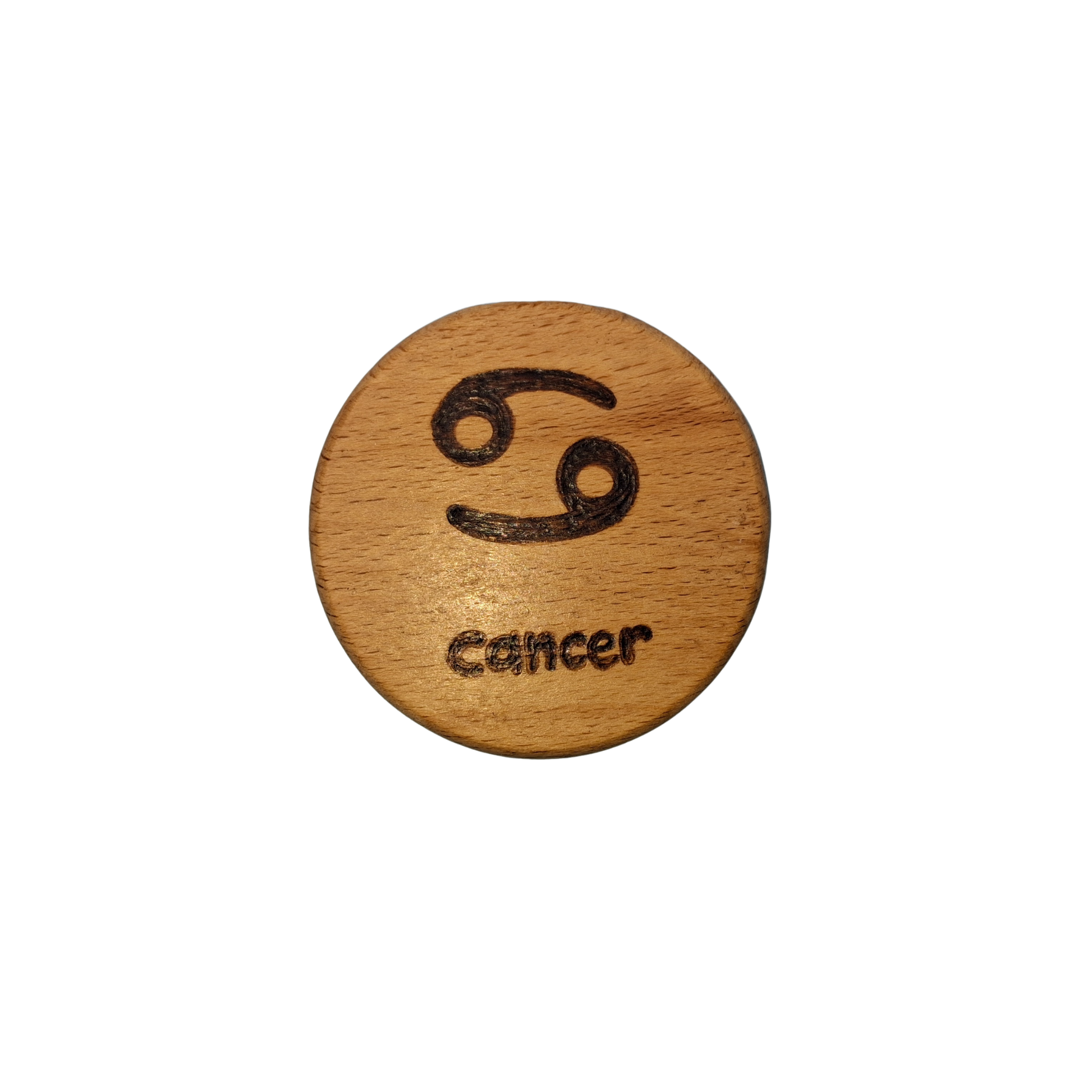 Close-up of a light-colored beechwood circle, 5cm in diameter and 0.4cm thick, featuring the words "Cancer" and an illustration of the star sign symbol,  hand-burned into its surface using pyrography. The wood has a smooth, waxed finish and the text is clearly legible.