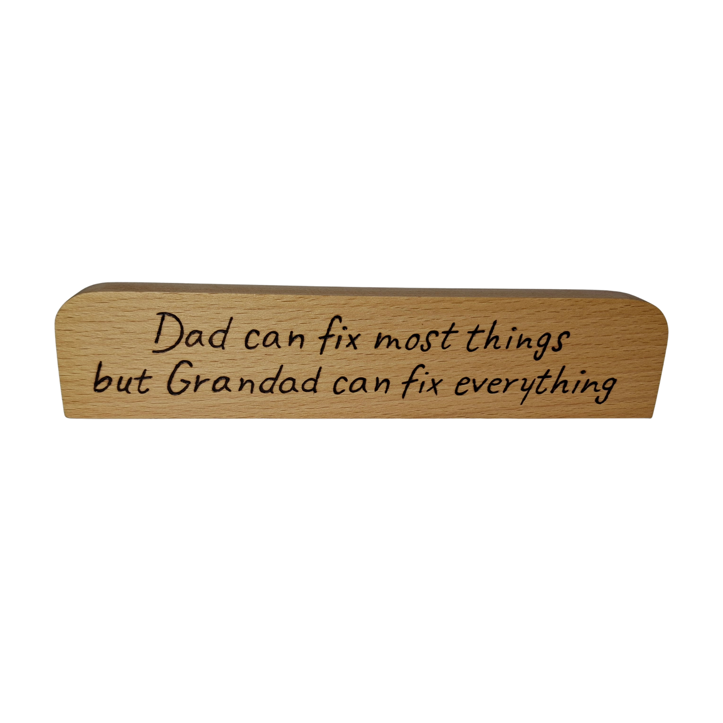 A long, narrow piece of light wood, rounded at the top and bottom edges, a desk plaque or sign. It features pyrography text that reads: "Dad can fix most things but Grandad can fix everything."