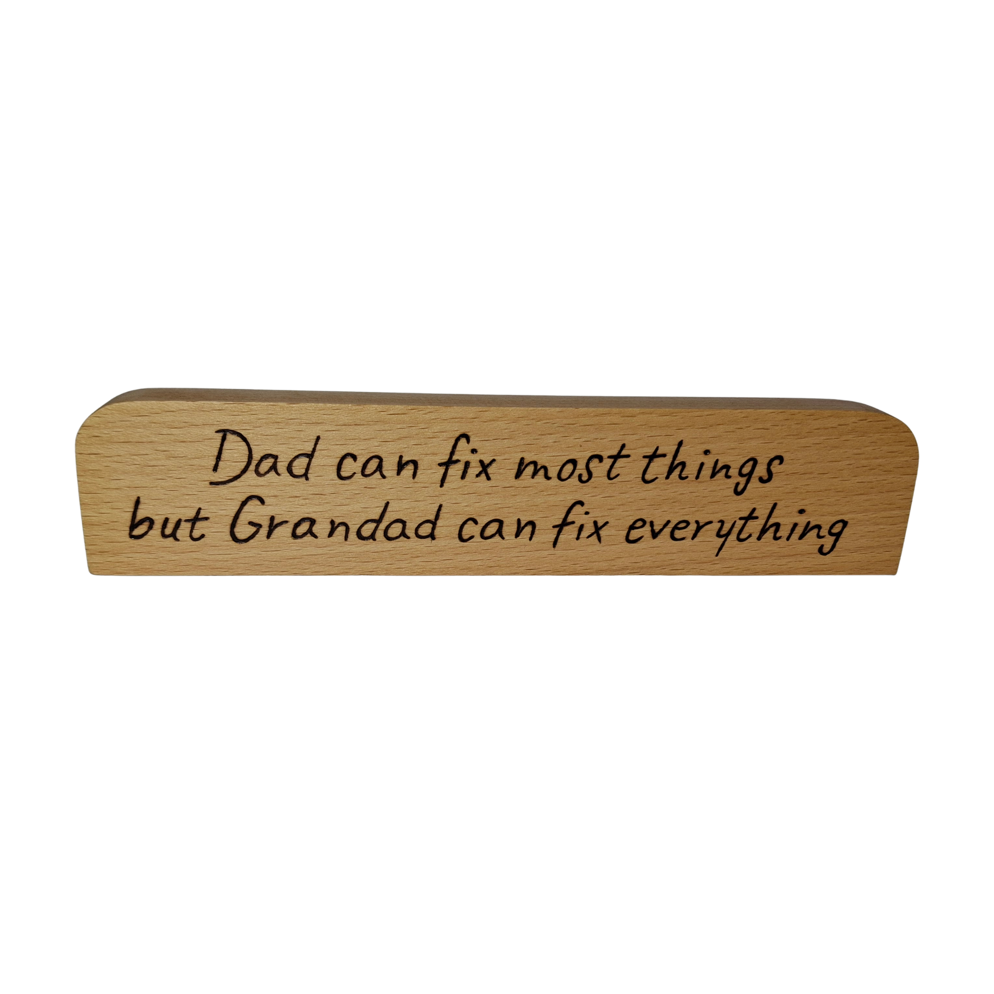 A long, narrow piece of light wood, rounded at the top and bottom edges, a desk plaque or sign. It features pyrography text that reads: "Dad can fix most things but Grandad can fix everything."