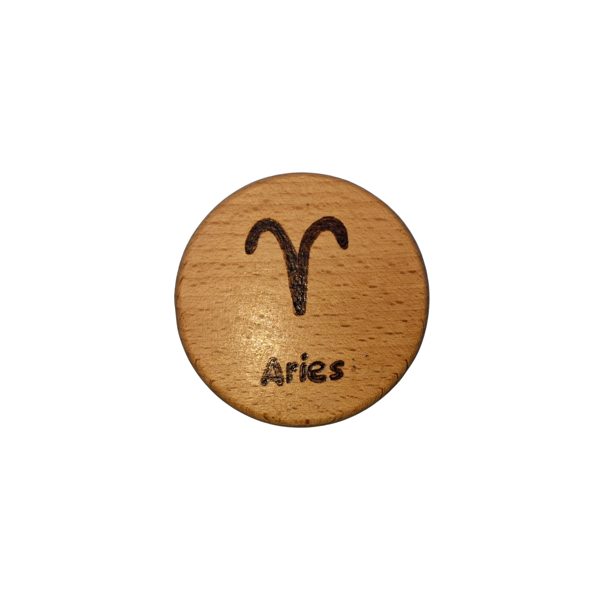 Close-up of a light-colored beechwood circle, 5cm in diameter and 0.4cm thick, featuring the words "Aries" and an illustration of the star sign symbol,  hand-burned into its surface using pyrography. The wood has a smooth, waxed finish and the text is clearly legible.