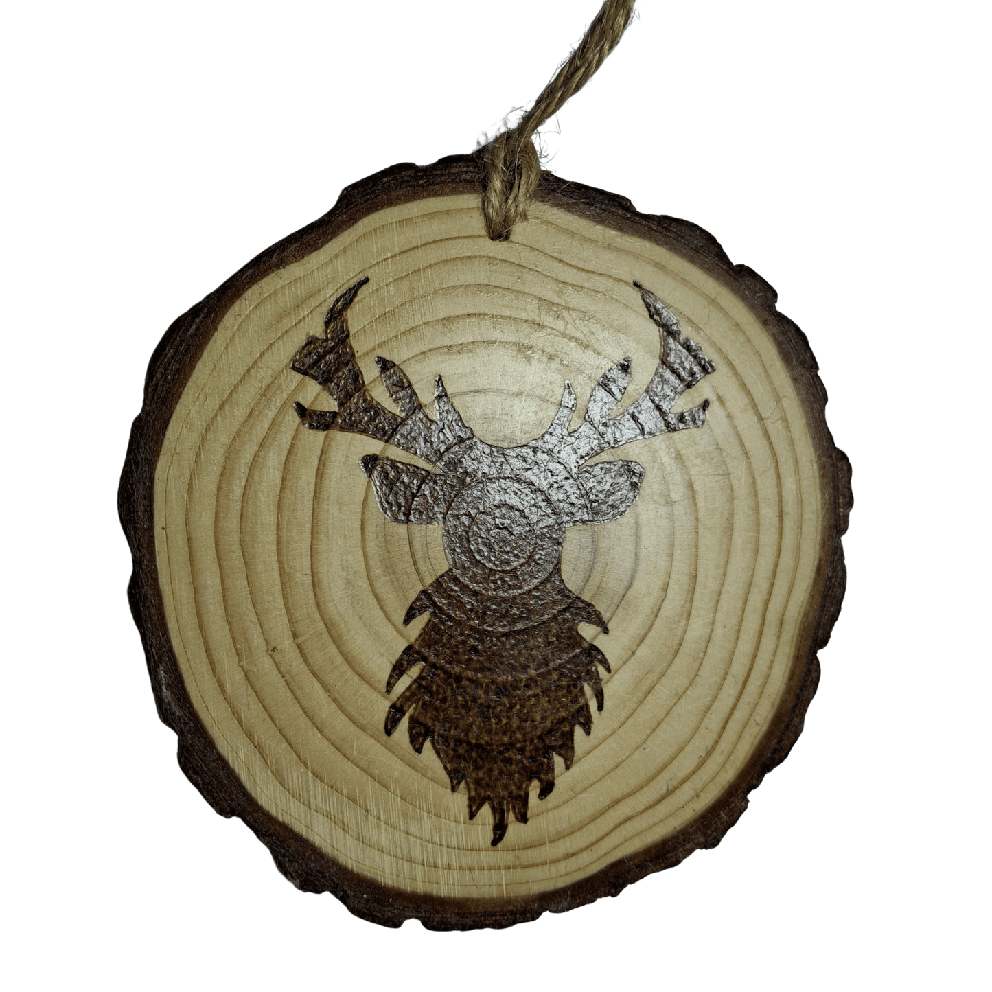 A round Christmas ornament, made from a wooden log slice, is shown on a black background. The ornament is decorated with a pyrography design of a stag's head with large antlers. A jute rope is attached at the top for hanging.