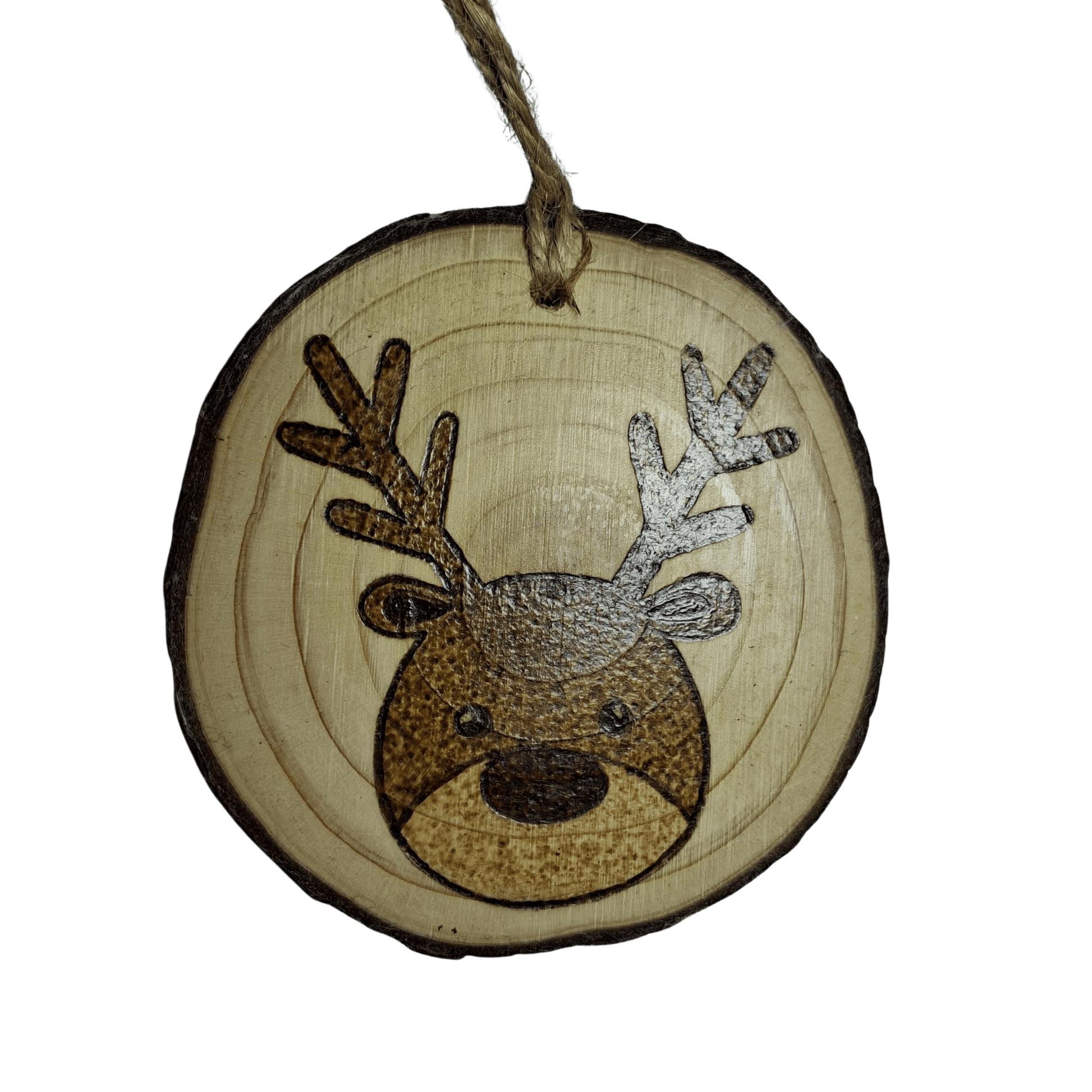 A round Christmas ornament, made from a wooden log slice, is shown on a black background. The ornament is decorated with a pyrography design of a cartoon reindeer's face with antlers. A jute rope is attached at the top for hanging.