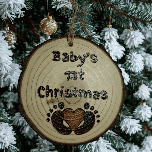 Wooden ornament with 'Baby's 1st Christmas' text and footprints on a Christmas tree background.