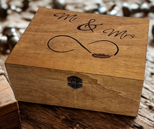 "Mr and Mrs" hand-burnt onto a wooden box top, featuring an infinity symbol and a delicate feather