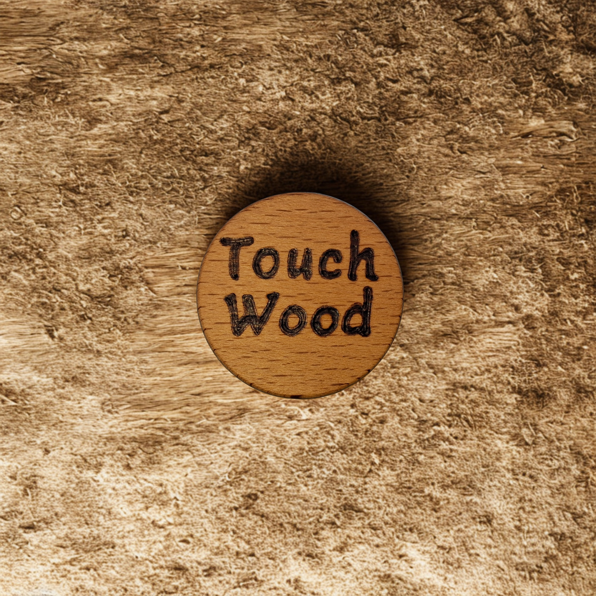 Close-up of a light-colored beechwood circle, 5cm in diameter and 0.4cm thick, featuring the words "Touch Wood" hand-burned into its surface using pyrography. The wood has a smooth, waxed finish and the text is clearly legible.