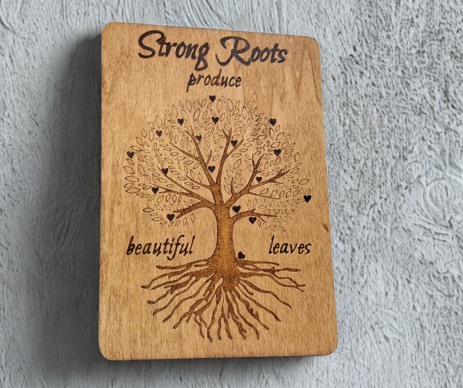 Decorative wooden plaque for family or heritage, intricately hand-decorated with "Strong Roots Produce Beautiful Leaves" text and a large, symbolic tree bearing heart-shaped leaves