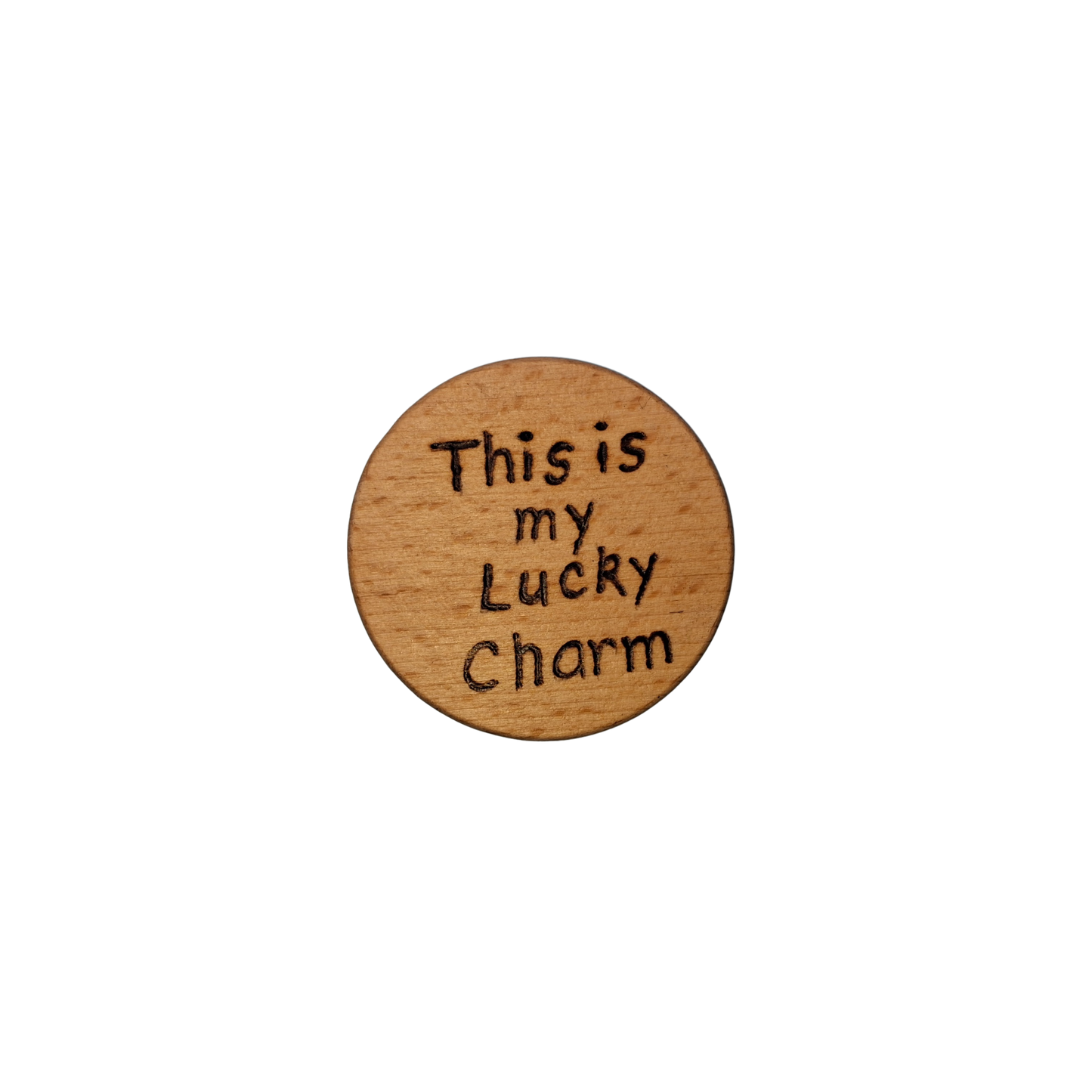 Close-up of a light-colored beechwood circle, 5cm in diameter and 0.4cm thick, featuring the words "This is my Lucky charm" hand-burned into its surface using pyrography. The wood has a smooth, waxed finish and the text is clearly legible.