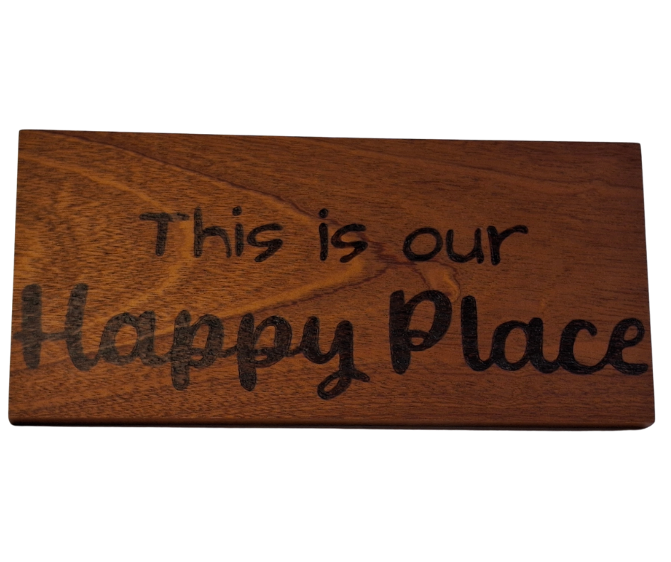 Decorative wooden plaque for a home, intricately hand-decorated with "This is our Happy Place" lettering.