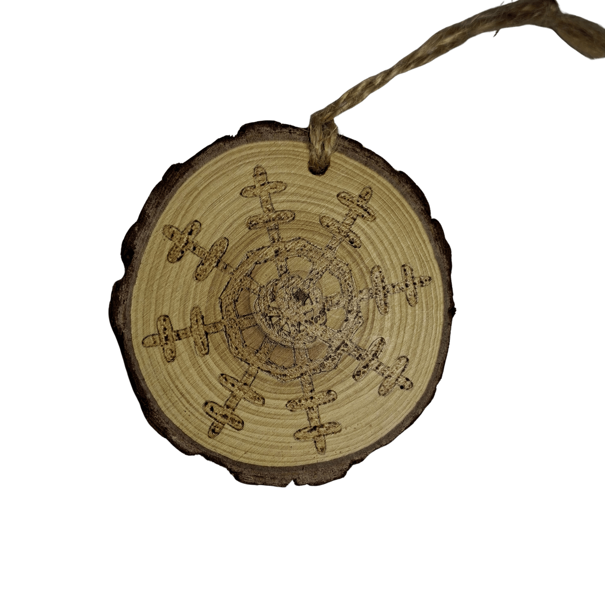 A wooden log slice Christmas ornament on a black background. The ornament is decorated with a detailed snowflake design burned into the wood using pyrography. A jute rope is attached at the top for hanging.