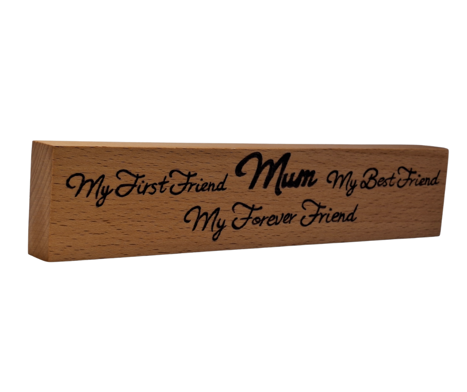 A hand-burnt, freestanding wooden plaque with the words "My first friend Mum My best friend My forever friend" in a casual, handwritten style. The wood has visible grain and a rustic, natural finish.