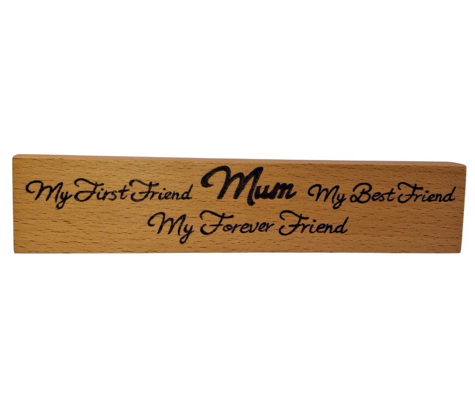 A hand-burnt, freestanding wooden plaque with the words "My first friend Mum My best friend My forever friend" in a casual, handwritten style. The wood has visible grain and a rustic, natural finish.