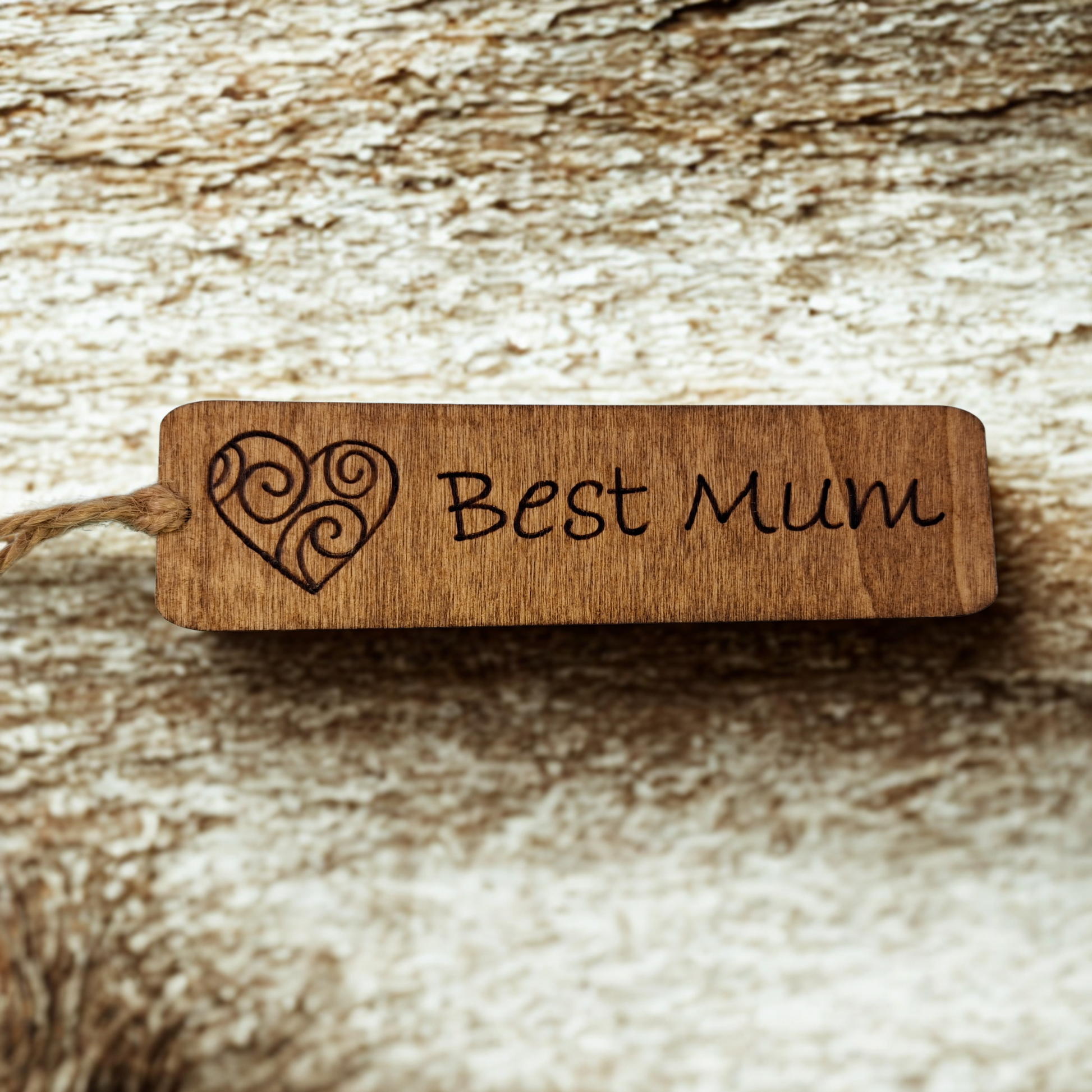 Dark wood bookmark with "Best Mum" pyrography and a patterned heart illustration.