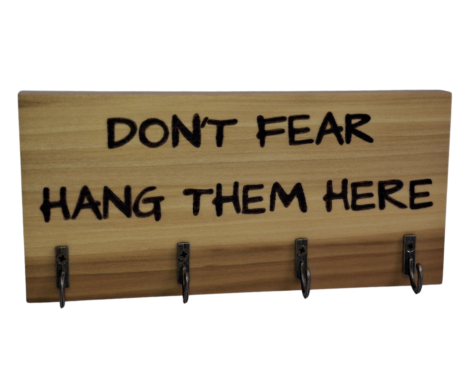  four-hook hanger crafted from two-tone Tulipwood, featuring hand-burnt lettering that reads "Don't Fear Hang Them Here." The wood has visible grain, showcasing its natural variations.